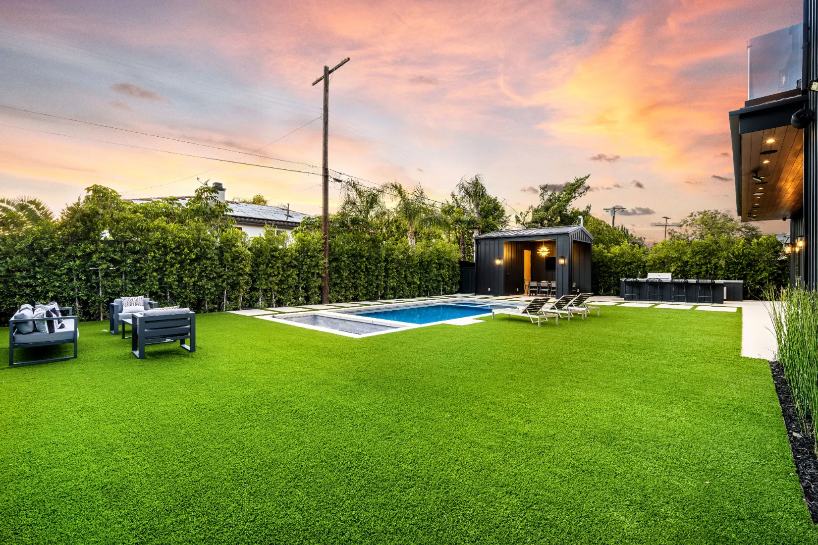 A luxurious backyard with swimming pool and a nice lawn.